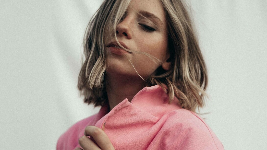 A woman wearing a desert rose color coat