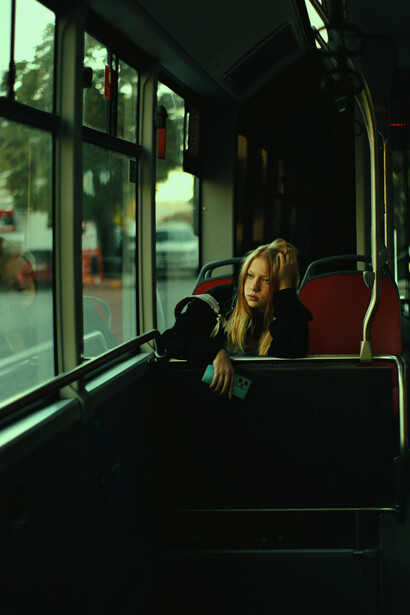 A blonde woman commuting alone by bus