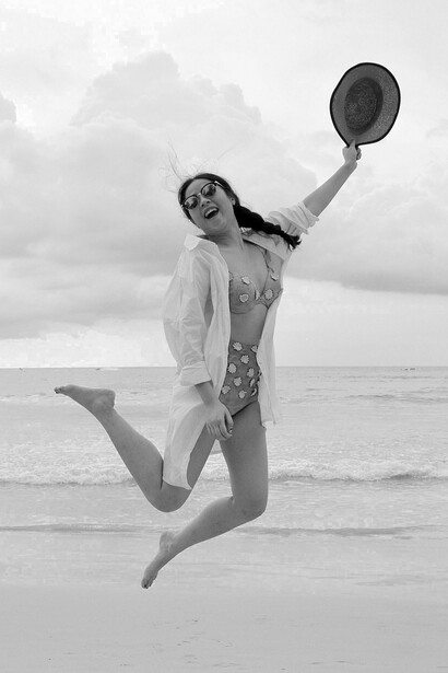 Una persona salta gioiosa in spiaggia