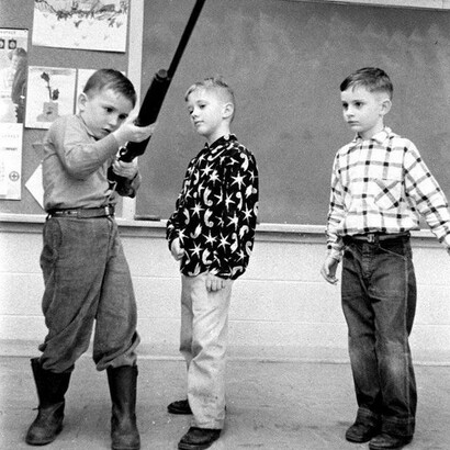 Niños manejando una escopeta en un aula