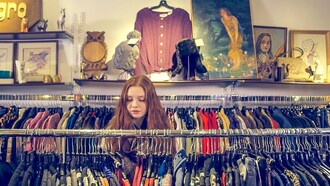 Moça compra roupas em brechó