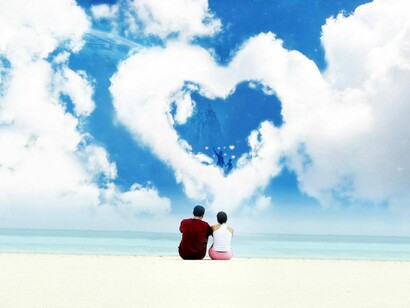 Una pareja de enamorados contempla una nube con forma de corazón