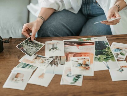 A young woman looking at photos, demonstrating how we can hold our past in our hand