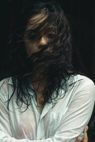 A woman drenched and looking drained, symbolising how some wounds take longer to heal and can pull you under the waves of grief at any moment