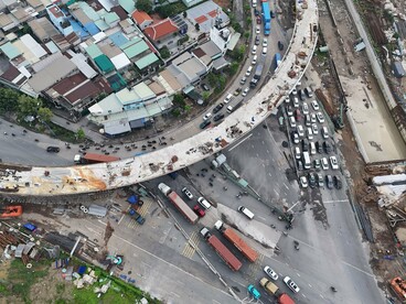 A congested intersection overshadowed by ongoing construction, symbolising the frustration of citizens waiting for promises of progress to become tangible improvements