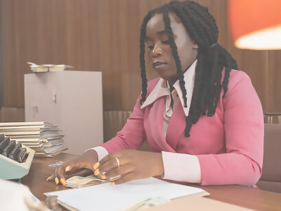 A woman counting cash at her work desk