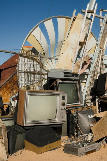 Discarded televisions and dismantled electronics gathered in a scrapyard, reflecting the increasing volume of global electronic waste
