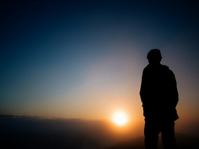 Hombre observa detenidamente el atardecer en soledad