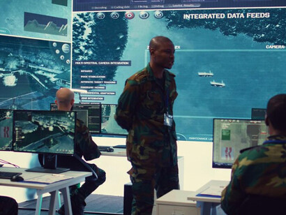 Military personnel working in a cyber security control room, monitoring multiple screens in a reconnaissance operations center