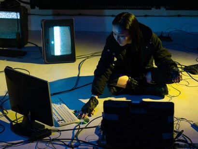 A cybersecurity professional working on multiple computer systems, representing the frontline of modern cyber conflict