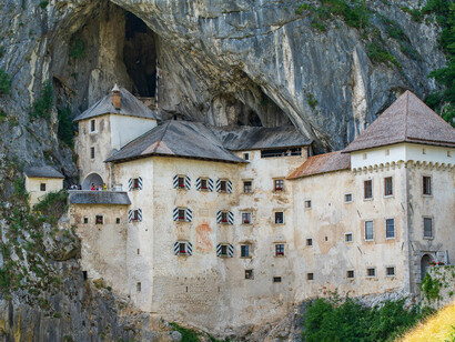Predjama Castle in Postojna, Slovenia, stands as a remarkable medieval fortress carved into the rock face