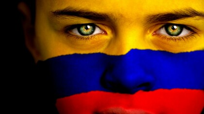 Joven con la bandera de Colombia en su rostro