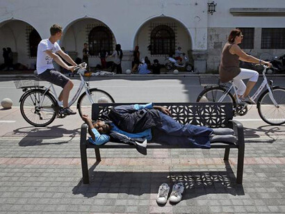 A refugee sleeping on a bench