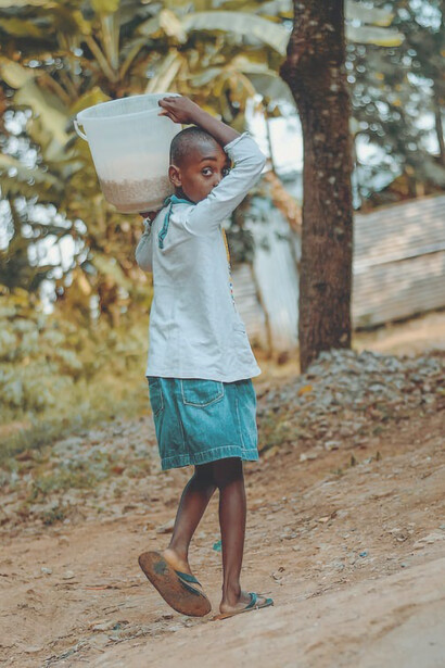 A child carrying food on his shoulder, Africa