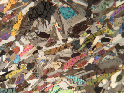 Lámina delgada de dolerita: observada en el microscopio petrográfico, dónde se distinguen minerales como el olivino, clinopiroxenos y plagioclasas principalmente. Rocas ígneas, que están representadas por bloques de doleritas rocas subvolcánicas, es decir, que no llegan a salir a la superficie, y que se emplazan en la corteza a través de fisuras o planos de debilidad existentes, donde el magma se va enfriando hasta formar la roca.