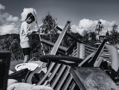 Survivors clearing through storm debris beneath an open sky, representing the quiet resilience born after disaster