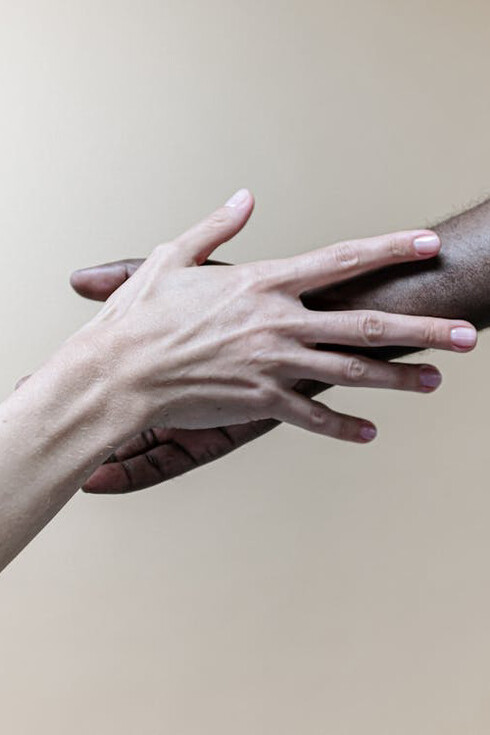 Amidst diverse backgrounds, hands unite in a powerful testament to the integration of human values, transcending personal goals to embrace the universal plan of harmony and understanding