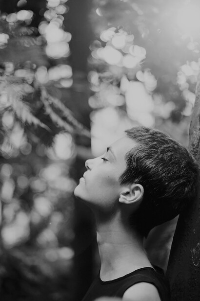 In the tranquil embrace of a garden, a woman stands gracefully, surrounded by a chorus of white flowers, their gentle beauty reflecting her own timeless elegance
