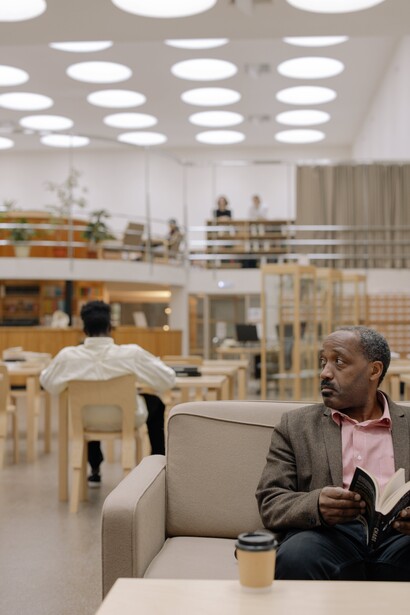 A man reading a book on a sofa. Vulnerability is not hidden