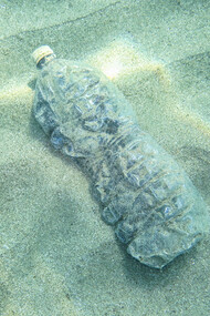 Botella de plástico en el fondo del mar