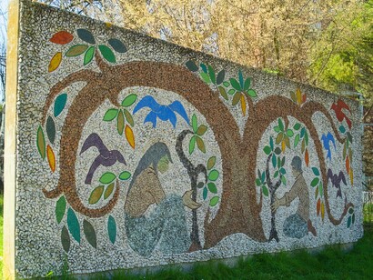 "L'albero della Vita", di Deru Josette, rappresenta la vita e la sua continua e necessaria rigenerazione: vi è raffigurato un albero dalle forme stilizzate e due giovani nell'atto di piantare piccoli arbusti. Le tessere utilizzate sono in pietra calcarea, granito e pasta vitrea.  Il pannello è grande, a sviluppo orizzontale; essendo esposto alle intemperie, possiamo affermare che a tutt'oggi è ben conservato