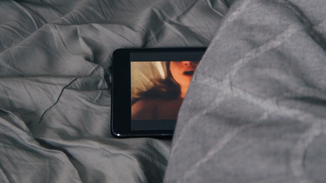 A mobile phone concealed beneath the bedsheets