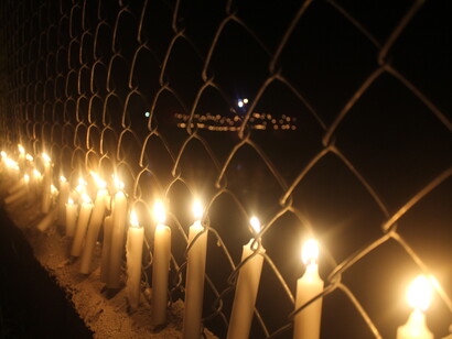 La verja que divide República Dominica y Haití decorada con velas encendidas. Foto de Matías Bosch Carcuro


