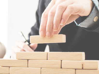 A businessman using wooden building blocks to symbolize career goals and work-life balance