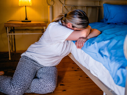A woman sitting alone on the floor and crying, portraying the emotional impact of abuse and depression