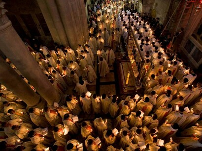 Cientos de fieles portando velas en una iglesia
