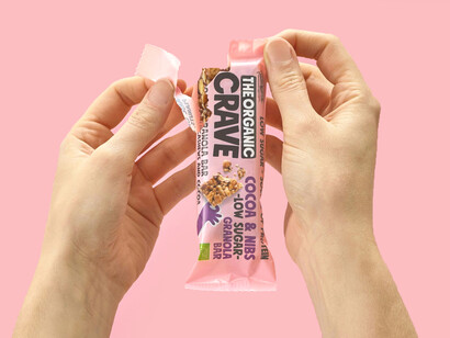 Organic low-sugar granola and muesli bars from The Organic Crave Company displayed on a table, shown in a close-up with visible natural ingredients
