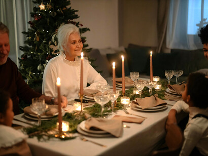A family gathers around the table, sharing a festive Christmas dinner together