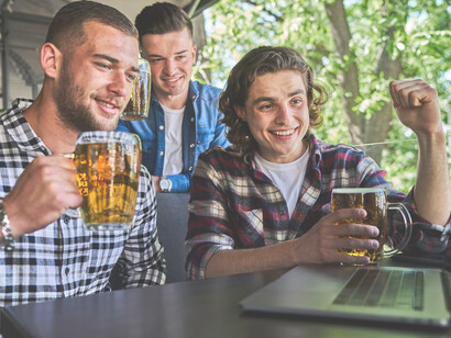 Three male friends gathered at a pub, sipping beer and enjoying a social evening with discussions about health and well-being