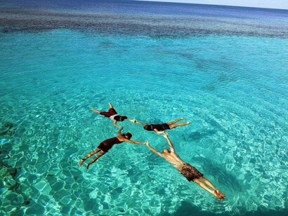 Turisti nella piacevole e sicura laguna che si trova in cima al lungo pontile privato del Derawan Dive Resort