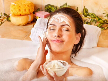 Una mujer aplicándose una mascarilla casera sobre el rostro