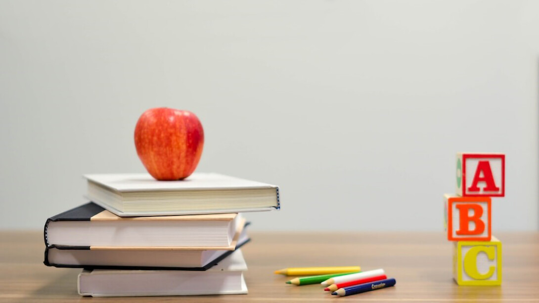 Red apple fruit on four pyle books