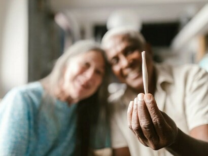 Two people relaxing and smoking a cannabis joint
