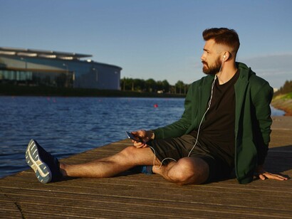 A man sitting by the waterfront, representing the value of stillness in a world that never stops