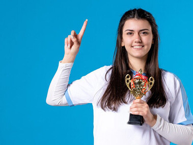 Female player proudly holding a trophy at a community recognition awards ceremony, celebrating public appreciation and achievement