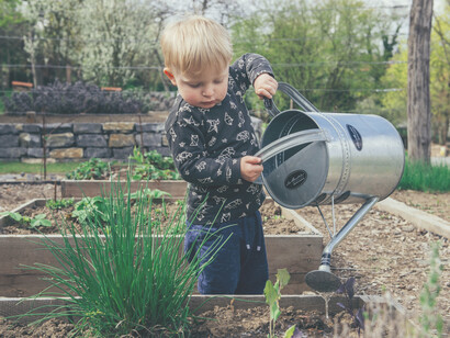 Niño riega las plantas del jardín familiar. Aquella calle diminuta y enjalbegada era un viaje a otra época