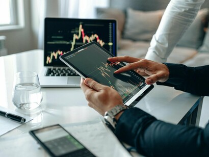 A user analysing live transaction trends on smart devices, reflecting the increasing need for instant risk detection and fraud prevention