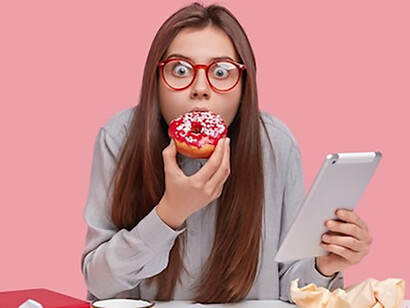 A woman holding a doughnut, her expression showing a craving and signs of sugar addiction