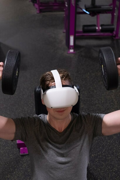 Wellness metaverse: man does arms workout with virtual reality gear