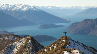 Persona en la cima de una montaña: creer en ti te aportará fuerzas para levantarte cada día sin perder la ilusión en tu proyecto
