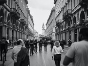 Persone che camminano in una strada ampia di una città durante una manifestazione in corso