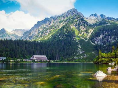 Green tree-covered mountains surround Popradské Pleso in the High Tatras, Slovakia