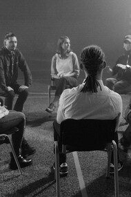 Grayscale photo of people sitting on chairs during a group therapy session