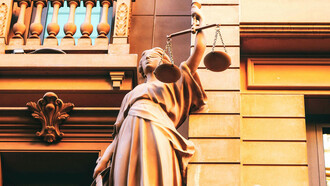 Statue der Justiz an der Fassade eines Gebäudes