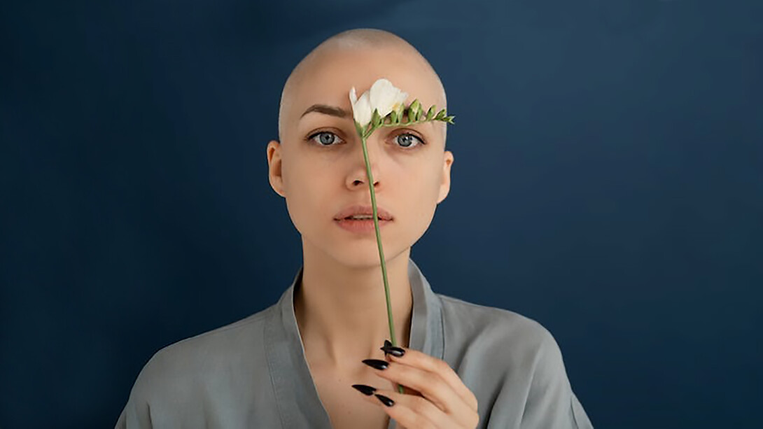 A woman with cancer holding flowers in her hand