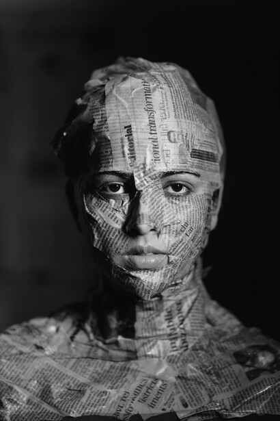Coberta por páginas impressas, a figura feminina transforma-se em metáfora visual da enxurrada informativa descrita no texto. Nem toda narrativa consegue silenciar a pluralidade das vozes. Em tempos de disputa narrativa, identidade e informação tornam-se cada vez mais entrelaçadas